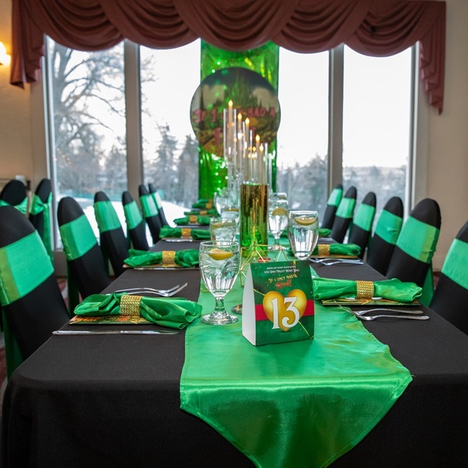 Fully dressed out table set in green, gold, and black decor.